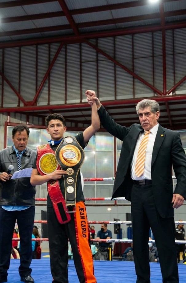 Campeon sostendiendo sus cinturones de campeonato